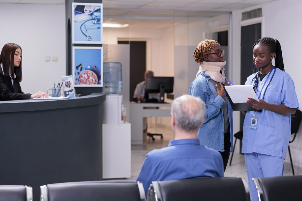 nurse consulting woman with neck collar brace giving healthcare support cure injury specialist patient talking about medical insurance treatment waiting room area injured adult 1024x683 4