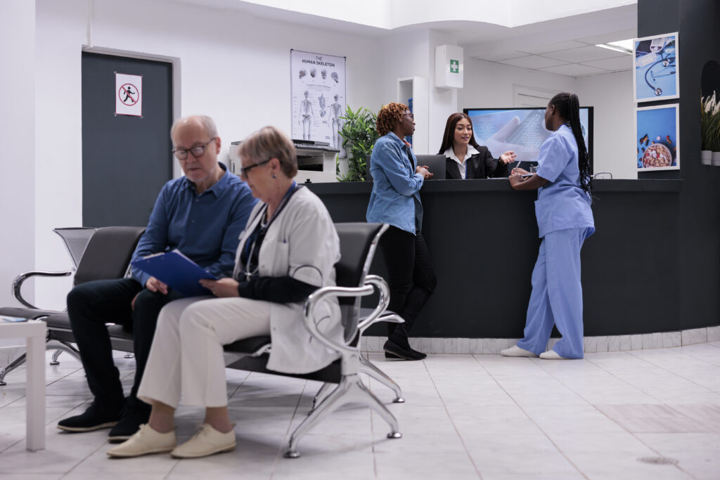 patient nurse sitting reception desk talking female receptionist about disease diagnosis healthcare support diverse people working health center registration counter 1 1024x683 2