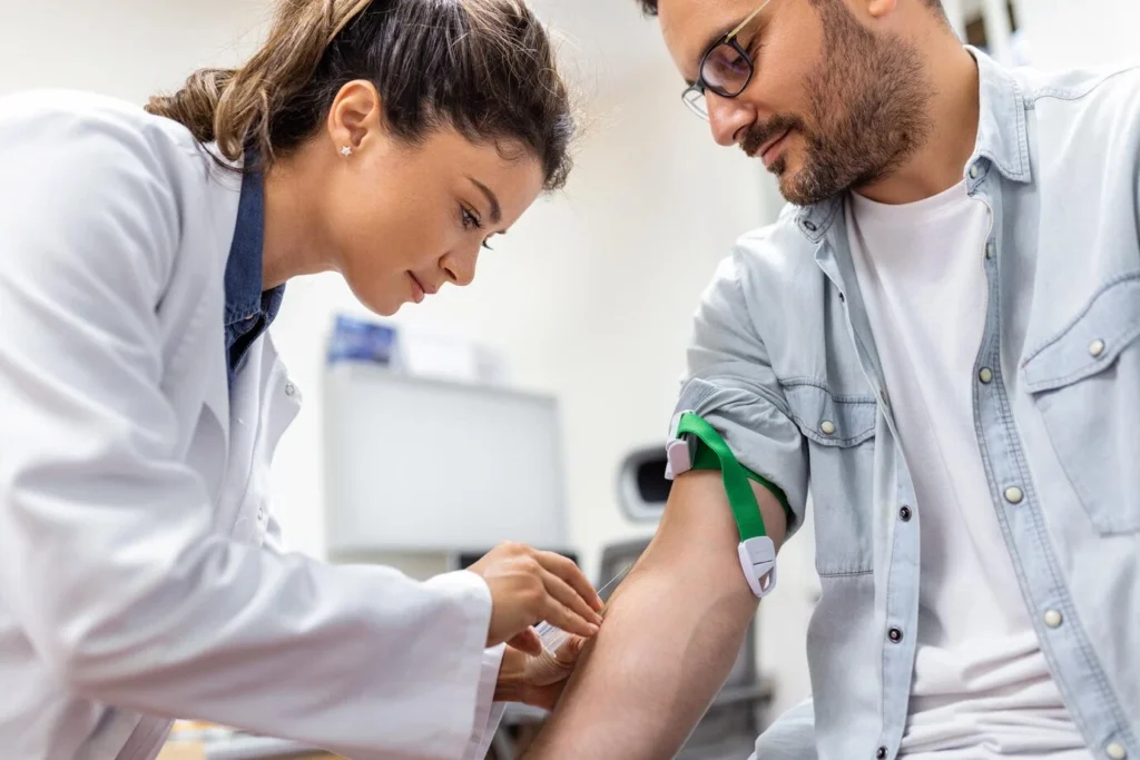 friendly hospital phlebotomist collecting blood sample from patient lab preparation blood test by fe 1024x683 2