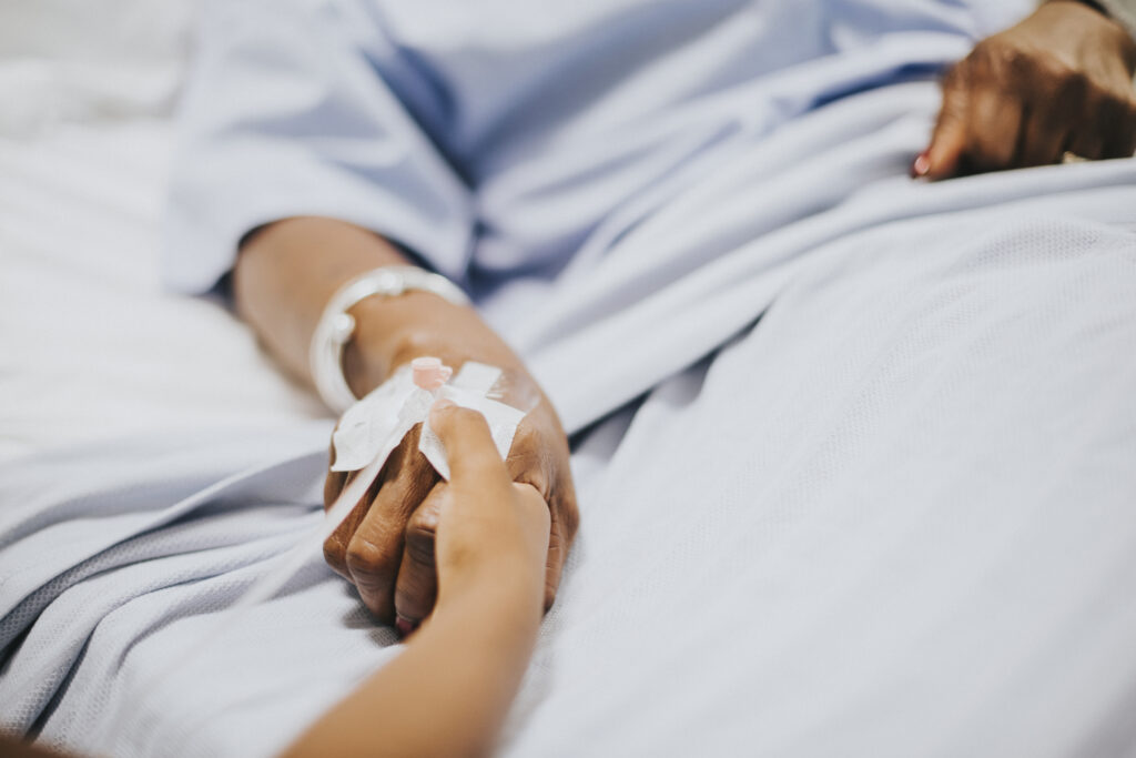 daughter holding her mothers hand hospital